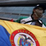 Un hombre utilizando una mascarilla sostiene una bandera en medio de manifestaciones en Bogotá, Colombia. Septiembre 7, 2020. REUTERS/Luisa Gonzalez