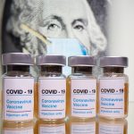 Un billete de 1 dólar con una mascarilla y varios frascos con etiqueta de vacuna para el COVID-19.. REUTERS/Dado Ruvic
