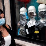 Una mujer pasa por delante de una tienda donde se exhiben mascarillas protectoras, después de que el gobierno anunció medidas más duras para combatir la propagación de la enfermedad coronavirus (COVID-19), en Roma, Italia.REUTERS/Remo Casilli