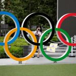 Una mujer utilizando mascarilla toma una fotografía a os anillos olímpicos frente al Estadio Nacional de Tokio, Japón REUTERS/Kim Kyung-Hoon