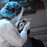 Una integrante de un equipo médico toma una muestra de un hisopo a un hombre en medio del brote de coronavirus, en Bogotá, REUTERS-Luisa Gonzalez