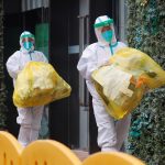 Dos trabajadores de la Organización Mundial de la Salud (OMS) con equipos de protección individual (EPI) encargados de investigar el origen del nuevo coronavirus (SARS-CoV-2) en Wuhan, provincia de Hubei, China. REUTERS/Thomas Peter