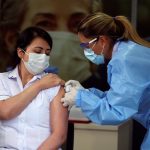 Claudia Benavides, enfermera de cuidados intensivos de la Clínica Colombia, recibe la primera dosis de la vacuna Pfizer-BioNTech COVID-19 en la Clínica Colombia