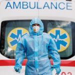 Un trabajador sanitario con un equipo de protección individual frente a una ambulancia en el exterior de un hospital para pacientes de COVID-19 en Kiev, Ucrania.  REUTERS/Gleb Garanich