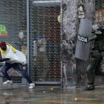 Una persona huye de un policía durante una protesta contra la reforma fiscal del Gobierno del presidente Iván Duque en Bogotá, Colombia, 1 de mayo, 2021. REUTERS/Luisa González