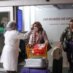 Una trabajadora de salud mide la temperatura de un viajero en una barrera sanitaria cuando llega al aeropuerto de Congonhas en Sao Paulo, Brasil, mayo de 2021. REUTERS/Amanda Perobelli