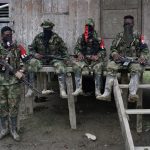 Guerrilleros del Ejército de Liberación Nacional (ELN) descansan frente a una casa cerca al río San Juan, en las selvas del departamento del Chocó. REUTERS/Federico Ríos