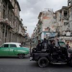 Un vehículo de las fuerzas especiales pasa junto a un coche de época en el centro de La Habana, Cuba. 13 de julio de 2021. REUTERS/Alexandre Meneghini