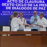 La jefa de la delegación del Gobierno Nacional de Colombia, Vera Grabe, y el jefe de delegación del ELN, Pablo Beltrán intercambian documentos